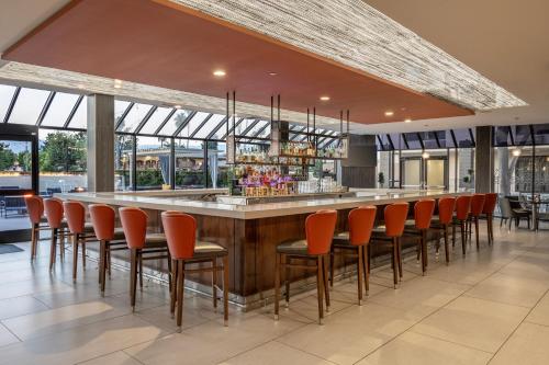 a bar in a restaurant with orange chairs at DoubleTree by Hilton San Bernardino in San Bernardino