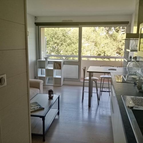 une cuisine et une salle à manger avec une table et une fenêtre dans l'établissement Les Hortensias, à Bénodet