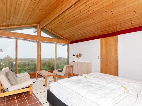 - une chambre avec un grand lit et quelques fenêtres dans l'établissement Holiday home Bindslev XVII, à Bindslev