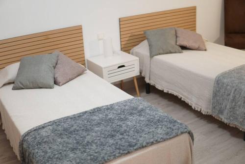 um quarto com duas camas e uma mesa de cabeceira em Casa Fausto Lasarte-oria em Lasarte-Oria