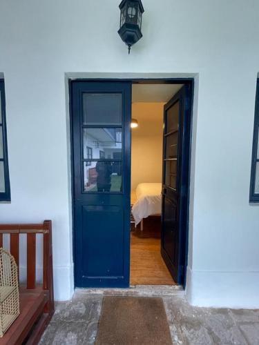 a blue door leading into a room with a bed at Illa B&B in Cusco