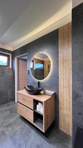 a bathroom with a sink and a mirror at Apartamenty Prestige Solina - jacuzzi i sauna in Solina