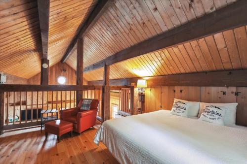 a bedroom with a bed and a chair in a room at Evergreen Chalet in Stowe