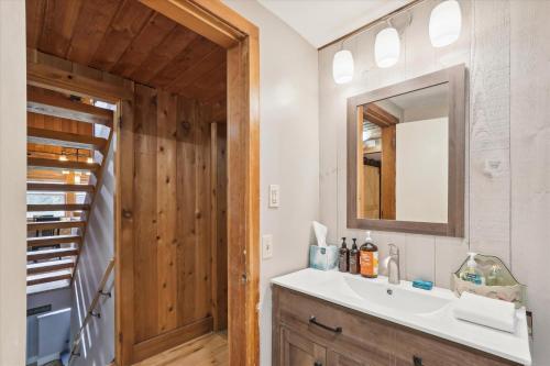 a bathroom with a sink and a mirror at Evergreen Chalet in Stowe