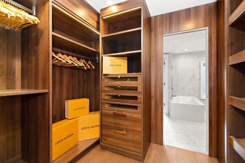 a walk in closet with wooden cabinets and a mirror at Luxurious 5 BR Townhouse in New York