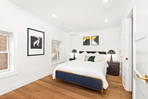 a white bedroom with a bed and a window at Luxurious 5 BR Townhouse in New York