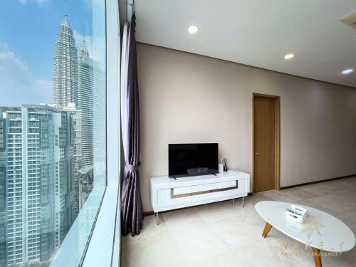 a living room with a tv and a large window at Soho Suites KLCC by Wakely Kuala Lumpur in Kuala Lumpur