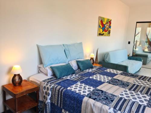 a bedroom with a king sized bed and a chair at B&B Pousada Swiss Residence in Aquiraz