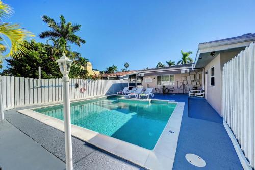 uma piscina em frente a uma cerca branca em Walk to Hollywood Beach Luxury 4BR Villa em Hollywood