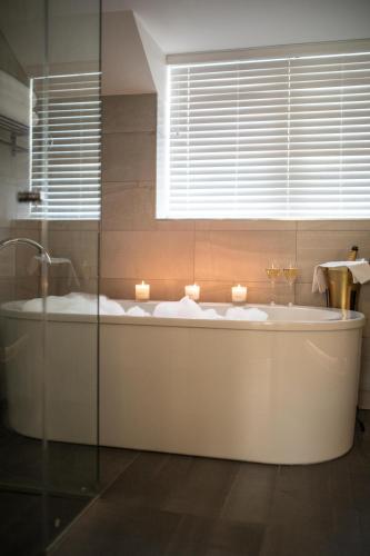 a bathroom with a tub with candles in it at Bedford Lodge Hotel & Spa in Newmarket