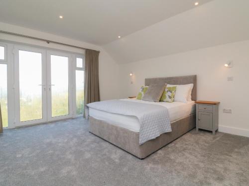 a bedroom with a large bed and large windows at Linden View in Ilfracombe