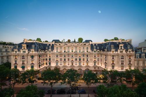 un grand bâtiment avec des arbres devant lui dans l'établissement The Peninsula Paris, à Paris