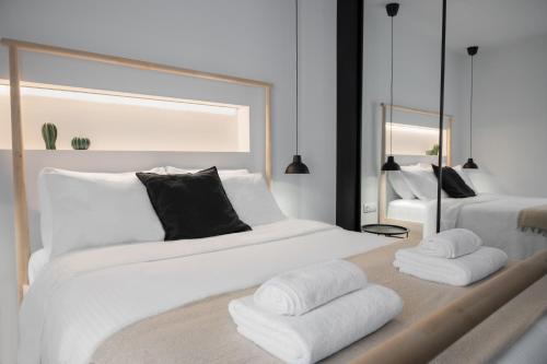 1 Schlafzimmer mit 2 weißen Betten und einem Spiegel in der Unterkunft Alyvia Central Apartment 1 in Ioannina