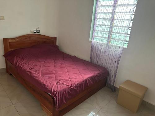 a small bedroom with a bed and a window at Maison paisible abomey calavie in Cotonou