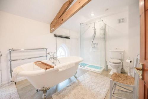 a bathroom with a tub and a shower and a toilet at The Old Chapel, Wissett in Halesworth