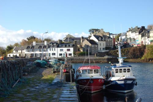 two boats docked in the water in a harbor at Roundstone Quay House in Roundstone