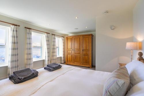 a bedroom with a large bed with two bags on it at Roundstone Quay House in Roundstone