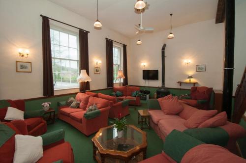 a living room with red couches and a tv at Makeney Chapel in Duffield