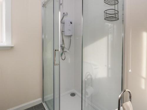 a shower with a glass door in a bathroom at Dunira in Mallaig