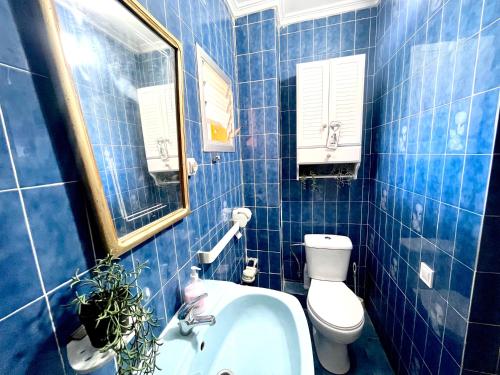 a blue tiled bathroom with a toilet and a sink at Room near the beach for 2 in Valencia