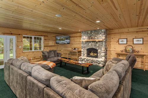 un soggiorno con divano e camino in pietra di River Road Lodge by NW Comfy Cabins a Leavenworth