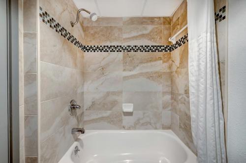 y baño con bañera blanca y ducha. en Motel 6 Arlington TX Entertainment District en Arlington