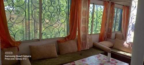 a room with windows and a couch with pillows at MON CHALET in Marrakech
