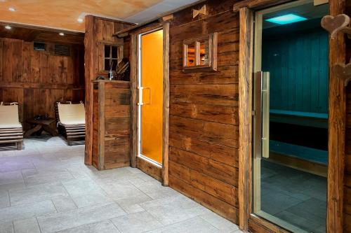 a wooden door leading to a patio with chairs at Hotel Belvedere in Cogne