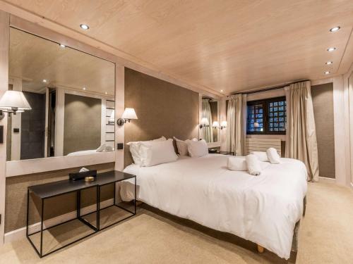 a bedroom with a large white bed and a table at Duplex 4 pers à Courchevel 1850 – Luxe et confort au pied des pistes - FR-1-631-175 in Courchevel