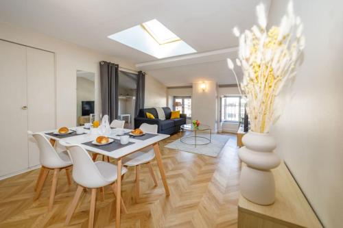 un salon avec une table, des chaises et un canapé dans l'établissement T2 cozy proche du centre avec canapé lit - 51Blatin, à Clermont-Ferrand