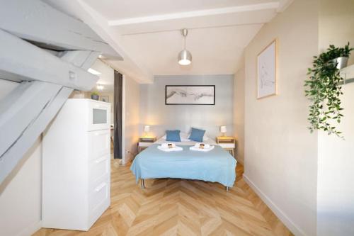 une chambre avec un lit avec des oreillers bleus dans l'établissement T2 cozy proche du centre avec canapé lit - 51Blatin, à Clermont-Ferrand