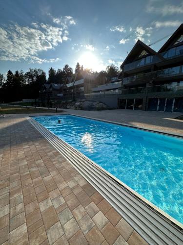 una grande piscina di fronte a un edificio di Kras-Resort Apartament 301 z widokiem na góry, prywatnym jacuzzi na tarasie i sauną a Szklarska Poręba