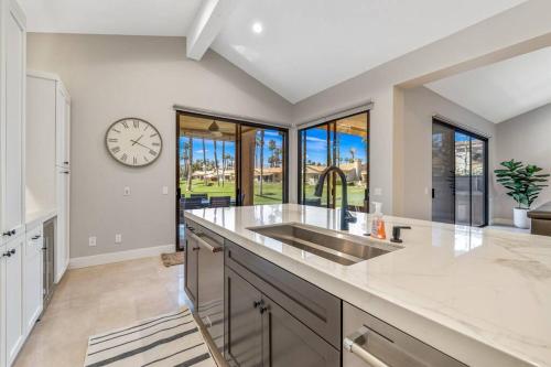 a kitchen with a sink and a clock on the wall at Beautiful Condo with Mountain & Sunset Views! in Palm Desert