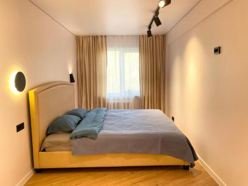 - une chambre avec un lit dans une pièce dotée d'une fenêtre dans l'établissement Apartment Dzerzhinskogo, à Öskemen