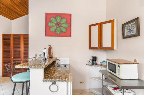 a small kitchen with a counter and a microwave at Villa del Sueño in Playa Hermosa