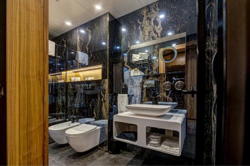 a bathroom with a sink and a toilet and a mirror at Hotel Vibre in Cluj-Napoca