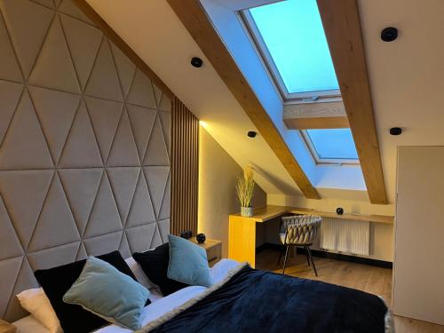 Un dormitorio con una cama grande con tragaluz. en ROYAL HILL II, en Białka Tatrzanska