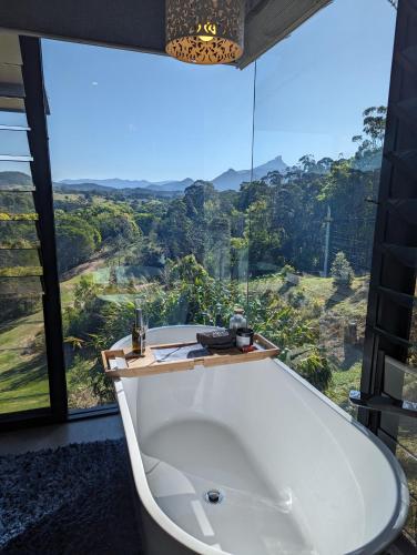 a bath tub in a room with a large window at La Rochér Eco Retreat in Stokers Siding