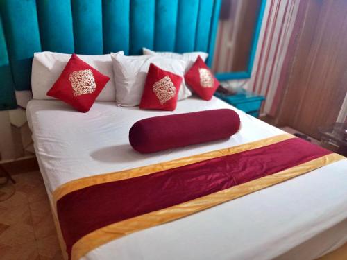 a bed with red and white pillows on it at Hotel Super Seven in Lahore