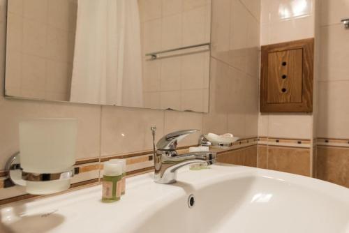 a bathroom with a sink and a mirror at Уютен апартамент с гледка в к-с Пирин Голф in Razlog