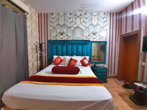 um quarto com uma cama grande e almofadas vermelhas em Hotel Super Seven em Lahore