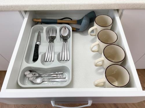 a drawer filled with utensils in a kitchen at Apartment Dzerzhinskogo in Ustʼ-Kamenogorsk