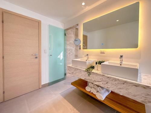 La salle de bains est pourvue de 2 lavabos et d'un grand miroir. dans l'établissement Fantastic brand new beach condo, à Punta Cana