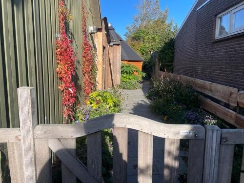 a wooden fence next to a garden with flowers at Kota Wadway in Spanbroek