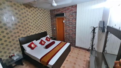 a bedroom with a bed with red pillows on it at Hotel Super Seven in Lahore