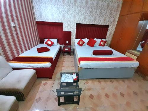 a hotel room with two beds and a couch at Hotel Super Seven in Lahore