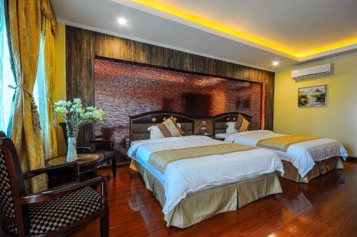 a hotel room with two beds and a table at Interpark Hotel in Olongapo