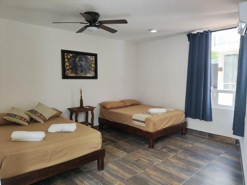 um quarto com 2 camas e uma ventoinha de tecto em Villas Carlota Cancún em Cancún