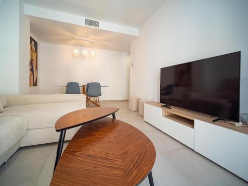 sala de estar con TV de pantalla plana grande en Piso Torno, en Sanlúcar de Barrameda