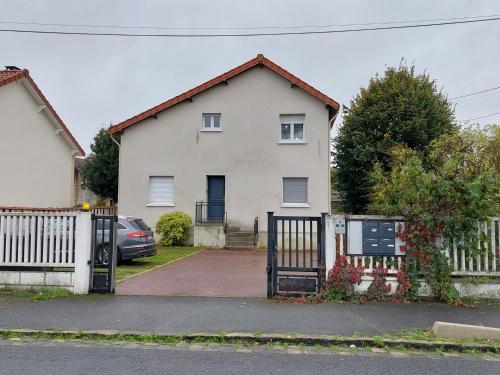 uma casa branca com um portão e uma cerca em Bel appartement au calme em Sainte-Geneviève-des-Bois